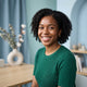 A friendly, diverse customer smiling in a professional headshot against a soft-focus blue and aqua studio background.